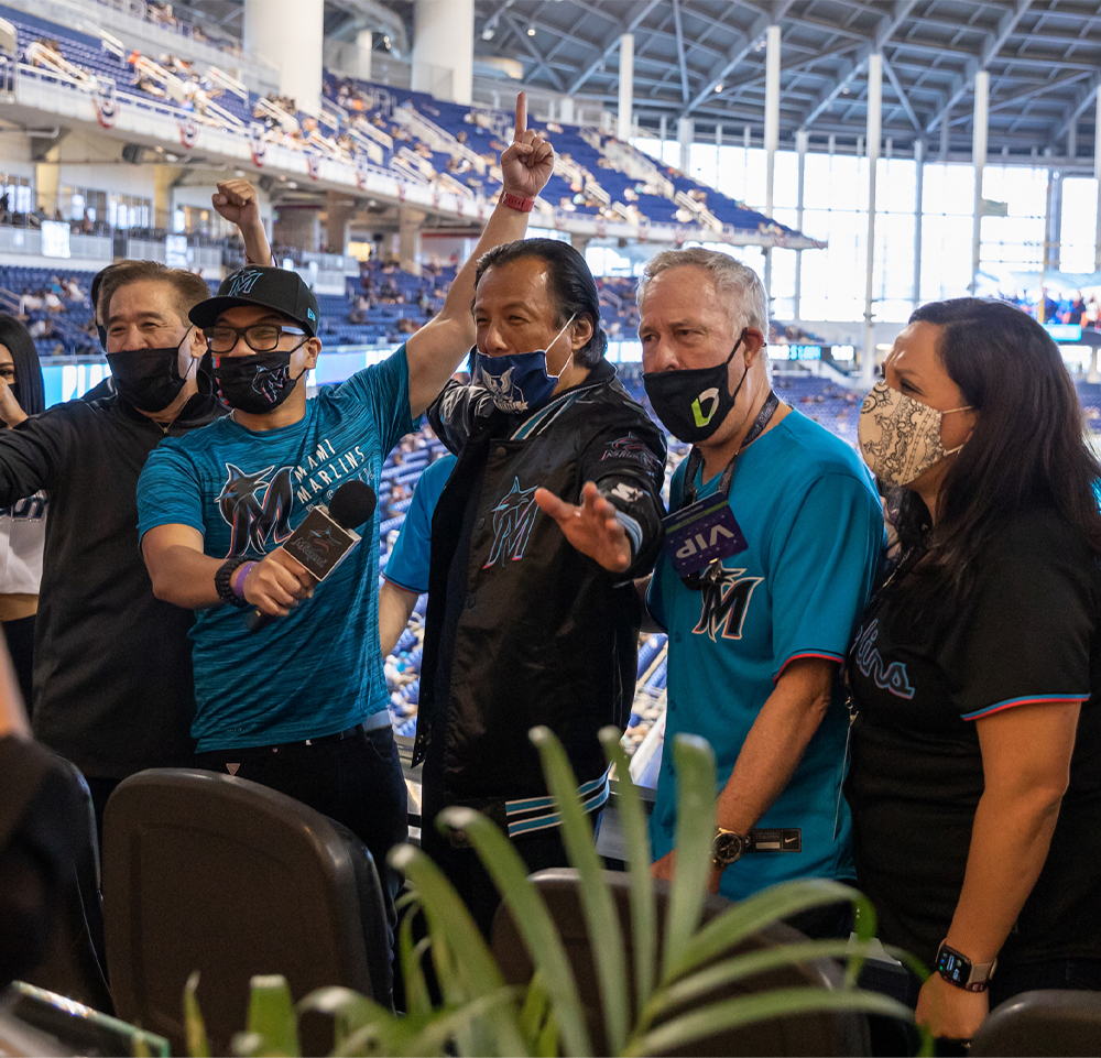 Group of people posing for a photo at a Miami Marlin's baseball game