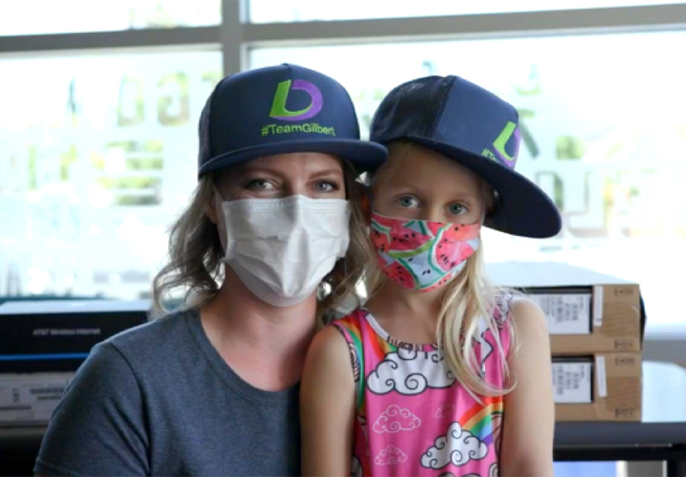 A woman and a little girl wearing Loan Depot hats and masks